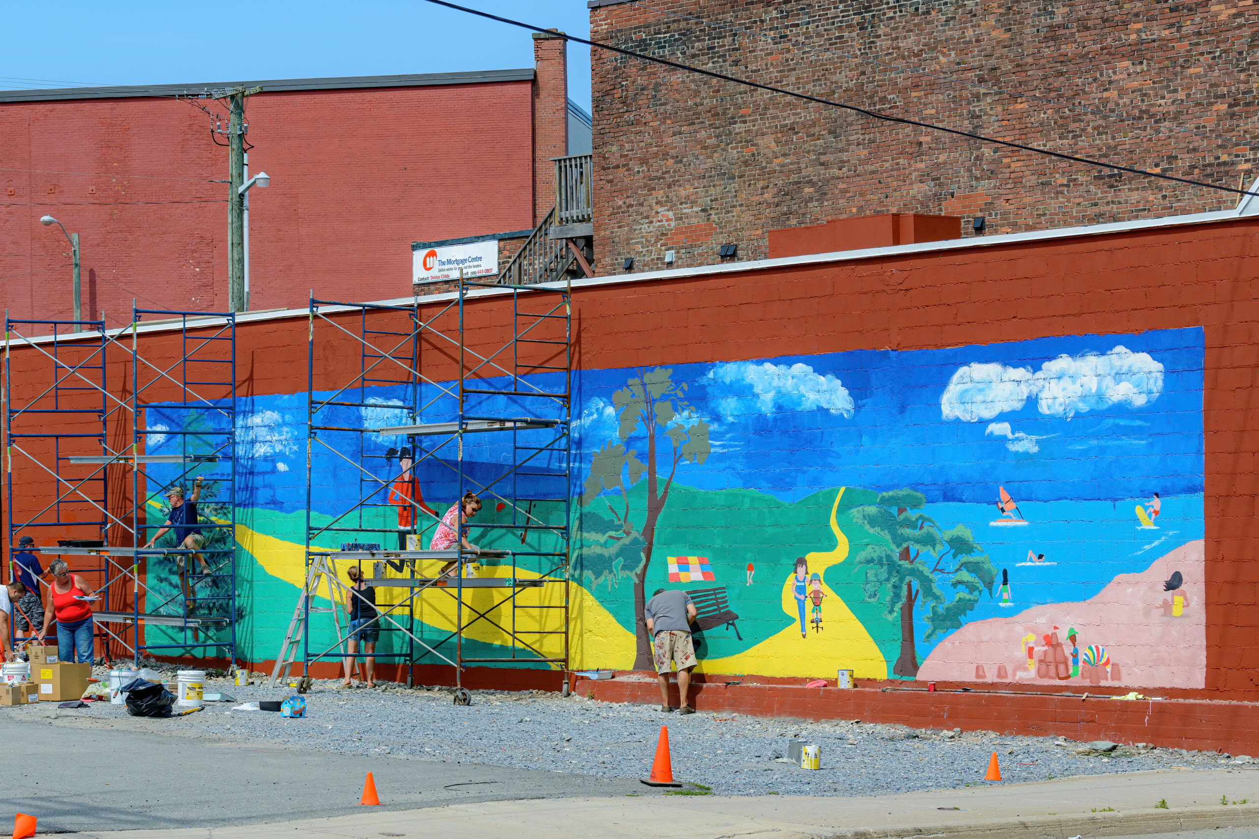 Picture of People Painting Colorful Mural on a Brick Wall in a City